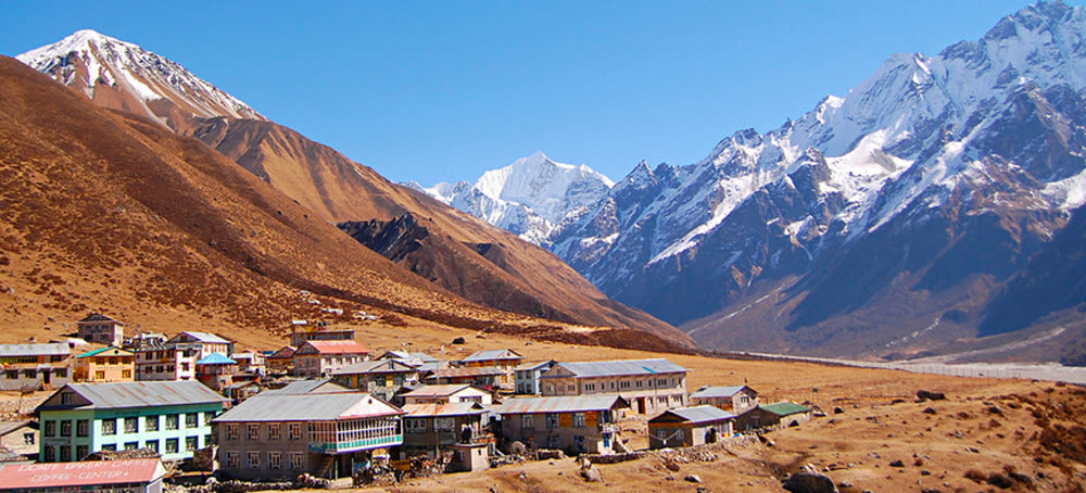 Snow-covered summits rising at the head of a broad brown valley