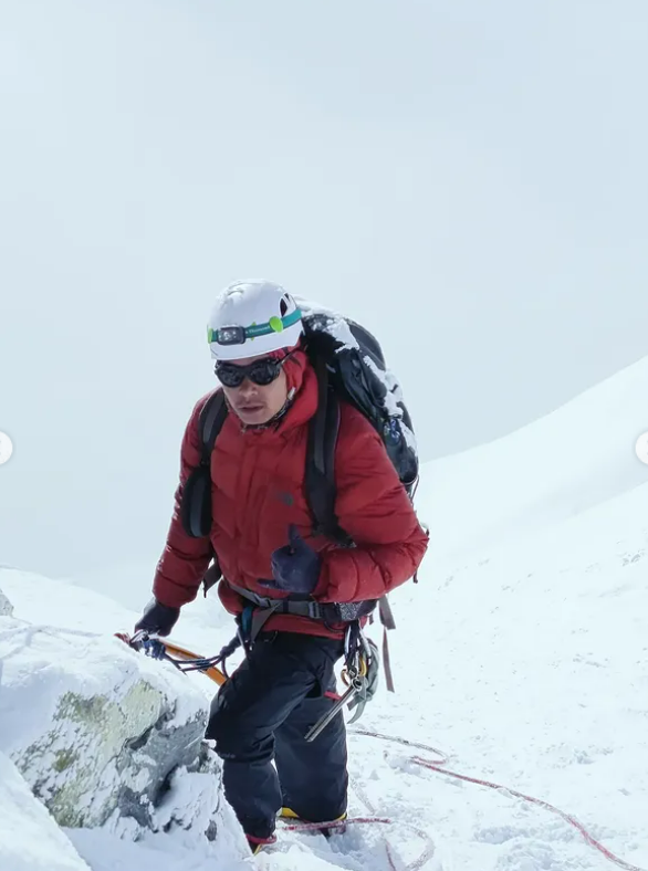 Surjan Syangdan climbing in full mountaineering kit on a snow slope in Nepal