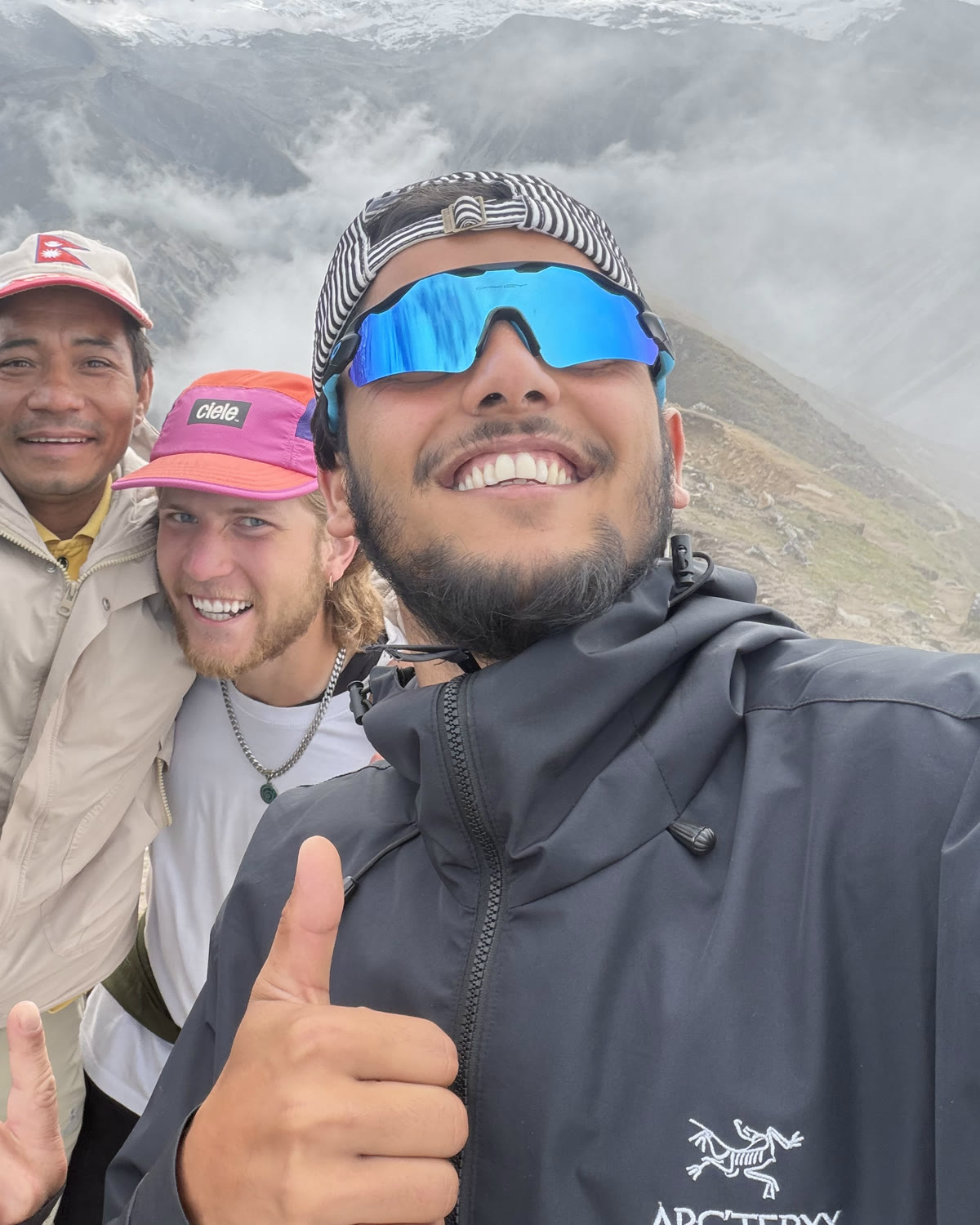 Sam Paudel, licensed trekking guide, with trekkers on a cloud-covered ridge in the Nepal Himalaya