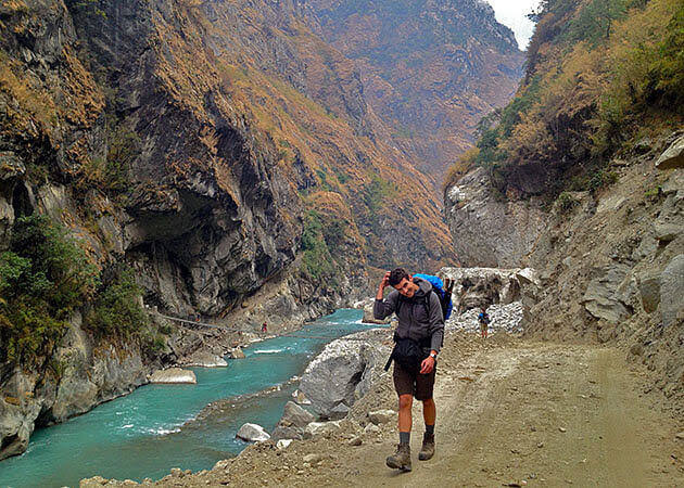 Trekker on the trail along the turquoise Budhi Gandaki gorge